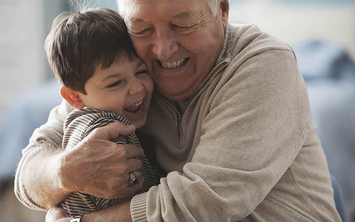Bunic cu implant Cochlear îmbrăţișându-și nepotul