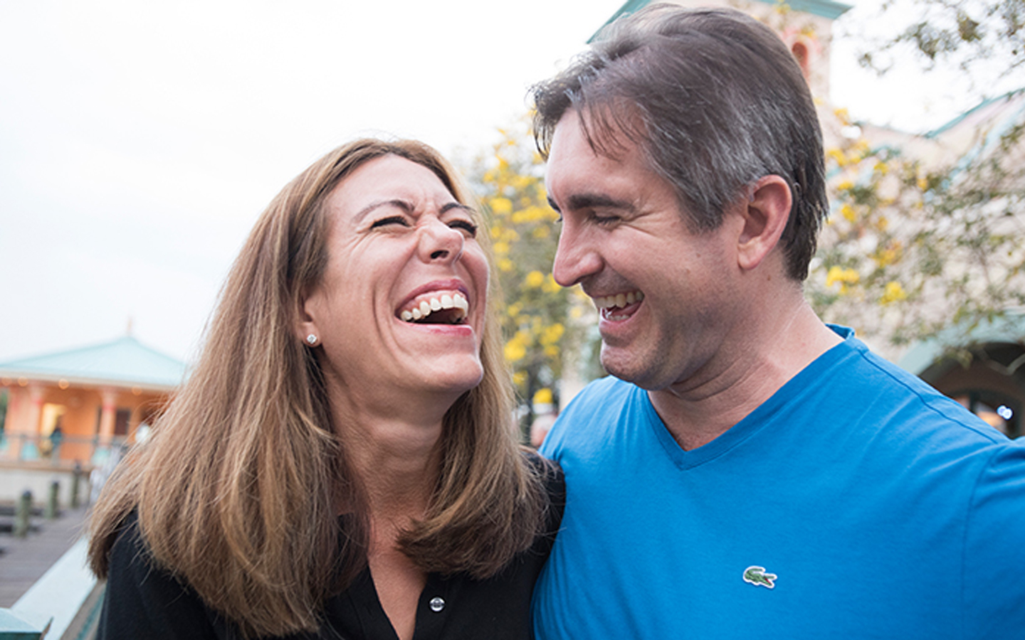 O soție și soțul său râd împreună pe stradă